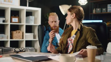 Geç saatlerde ofiste çalışan iş adamları. Hipster çift içeride konuşuyor.