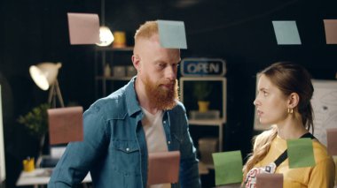 Gece ofisindeki cam tahtanın yakınındaki çiftler projesini kapatıyorlar..