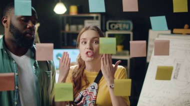 Karışık ırk çiftleri hippi ofisinde tartışıyor. Stresli kadın çıkartmaları çıkarıyor.