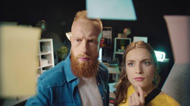 İş adamı ofisteki yönetim kurulundan çıkartma çıkarıyor. Genç çift notlara bakıyor.