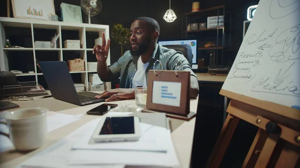 Θετικός Αφροαμερικάνος επιχειρηματίας που χρησιμοποιεί υπολογιστή στο χώρο εργασίας αργά το βράδυ. — Φωτογραφία Αρχείου