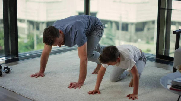 Pai e filho a praticar desporto juntos. Pai e criança sorrindo após o treino em casa — Fotografia de Stock