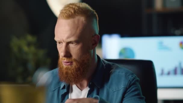 Un hipster concentrado llenando datos en la computadora de la oficina nocturna. Hombre mirando la pantalla — Vídeos de Stock