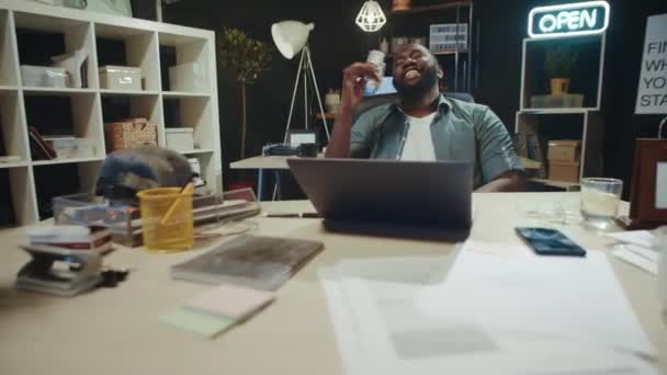 Нахабний бізнесмен - афроамериканець, який користується запахом грошей у гіпстерському офісі.. — стокове відео