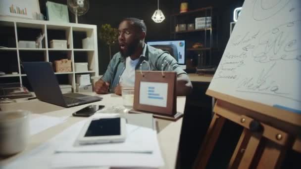 Elégedett afro-amerikai férfi ünnepli sikerét hipszter coworking. — Stock videók