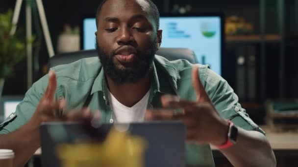Närbild allvarliga afro affärsman diskuterar projekt genom videochatt inomhus — Stockvideo