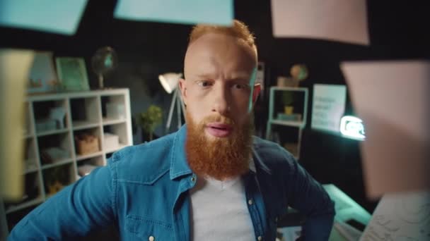 Gülümseyen kızıl saçlı adam, hipster ofisinde iyi çözümü olan bir etiket buluyor.. — Stok video