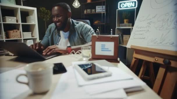 Un empresario africano sonriente que acaba de trabajar en coworking. Feliz afro chico relajante — Vídeos de Stock
