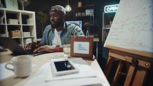 L'homme africain concentré travaille sur l'ordinateur au bureau. Afro gars la recherche de données en ligne — Video