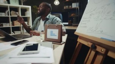 Neşeli Afrikalı iş adamı ofisinde dolarları sallıyor. Paralı afro adam.