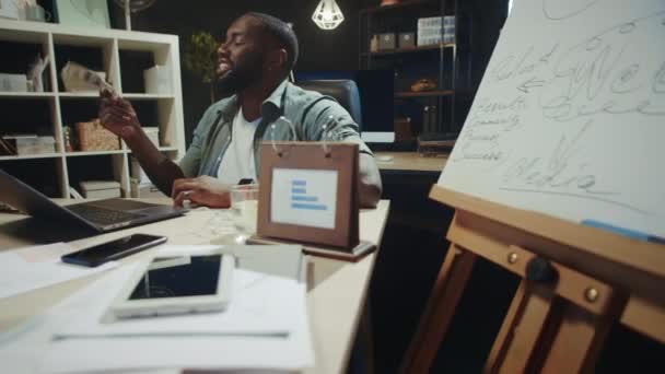 Cheerful african businessman waving dollars bills in office. Afro guy with money — Stock Video