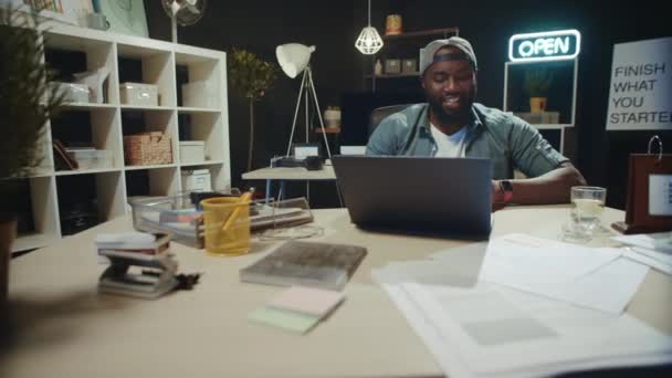 Vrolijke afro zakenman werkt online in moderne coworking. — Stockvideo