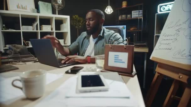 Gestionnaire afro-américain épuisé éteignant l'ordinateur à l'espace de travail. — Video