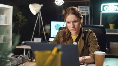 Stresli iş kadını karanlık ofiste bilgisayar sorunları yaşıyor..