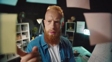 Kafası karışmış hippi adam karanlık ofiste çalışan tahtada doğru etiketi seçmeye çalışıyor..