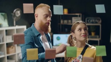 Modern iş adamı hipster ofisindeki kadın meslektaşının dikkatini çekiyor.