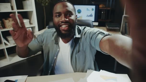 Портрет усміхненого афро-чоловіка, який привітався з камерою на робочому місці хіпстера . — стокове відео