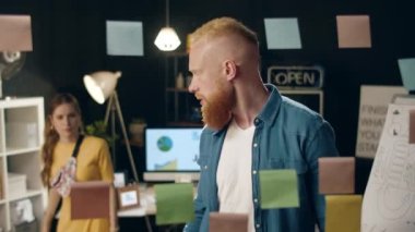 Sinirli hippi adam gece ofisindeki bayan meslektaşına projeyi açıklıyor.