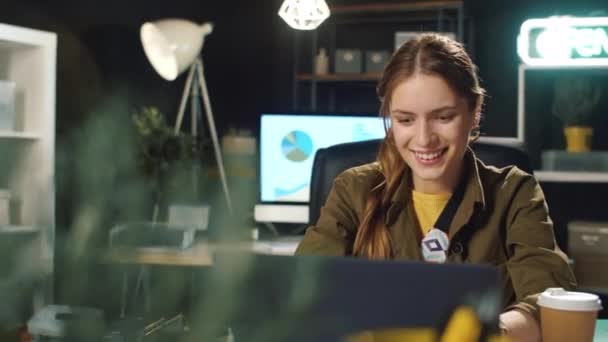 Sorridente donna d'affari digitando online dopo il lavoro in ufficio hipster a tarda notte. — Video Stock