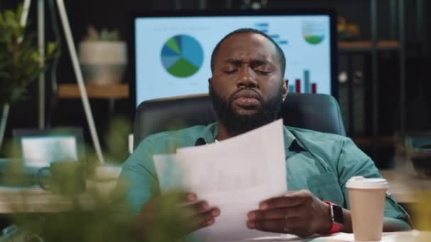 Vermoeide Afrikaan die koffie drinkt op kantoor. Uitgeputte afro man geeuwt binnen — Stockvideo