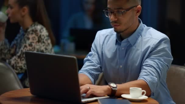 Indischer Geschäftsmann mit Laptop im Café. Männlicher Programmierer arbeitet am Laptop — Stockvideo
