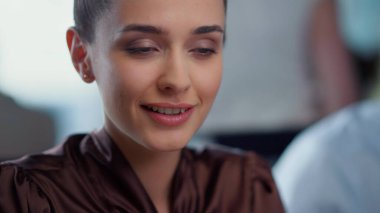 İş kadını işyerinde iyi haberler okuyor. İş kadını kameraya kur yapıyor.