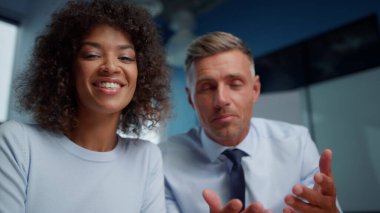 Neşeli iş adamı ve iş kadını müşterilerle çevrimiçi video konferansı yapıyor