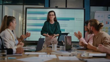 Finans müdürü iş arkadaşlarıyla başarıyı kutluyor. Takım el ele tutuşuyor.