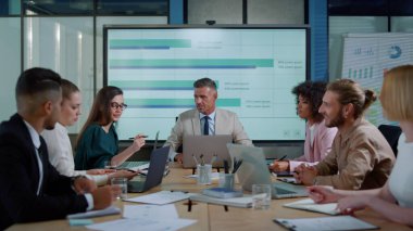 Finans müdürü yöneticilerle strateji tartışıyor. Beyin fırtınası yapan takım fikirleri