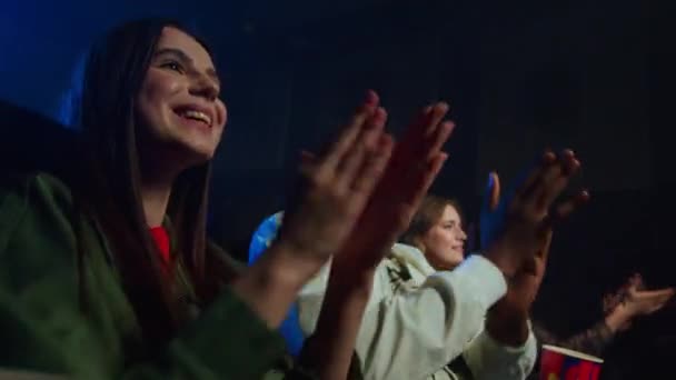 Usmívající se lidé tleskající v temné síni. Veselí přátelé baví v kině. — Stock video