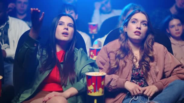 Frustrované ženy gestikulují v kině. Rozrušené dívky sledující film uvnitř. — Stock video