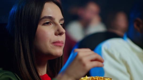 Mulher bonita comendo pipocas no cinema. Menina atraente assistindo filme. — Vídeo de Stock