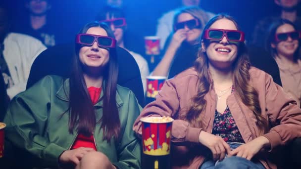 Smiling women laughing indoor. Cheerful girls eating popcorn in cinema. — Stock Video