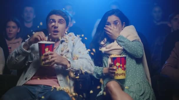 Un uomo scioccato che versa popcorn al cinema. Amici che saltano nel cinema. — Video Stock