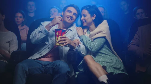 Romantic couple hugging in movie theater. Cheerful people having fun in cinema.