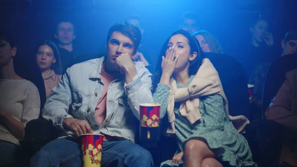 Сонная женщина зевает в кино. Уставшая пара смотрит фильм в кинотеатре. — стоковое фото