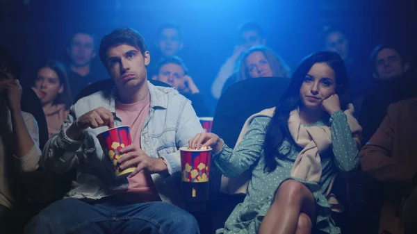 Casal perturbado a comer pipocas no cinema. Amigos assistindo filme no cinema. — Fotografia de Stock