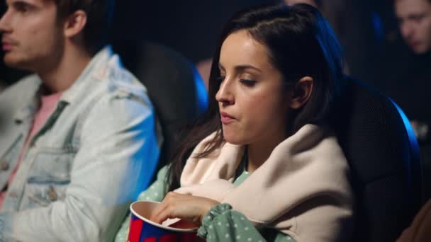 Ragazza stressata che guarda un film in una sala buia. Bella donna sorprendente nel cinema. — Video Stock