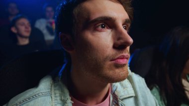 Sinemada film izleyen şaşkın adam. Sinemada gülümseyen neşeli adam..