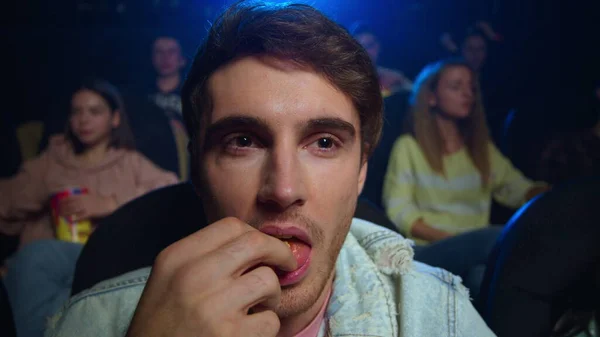 Hombre alegre comiendo palomitas de maíz en el cine. Sonriente chico buscando comedia interior. —  Fotos de Stock