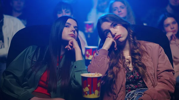 Menina entediada assistindo filme no salão escuro. Mulher irritada bocejando no cinema. — Fotografia de Stock