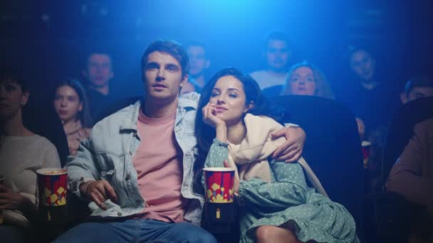 Aşk çifti sinemada sarılıyor. Sinemada kadınları öpen mutlu adam.. — Stok video