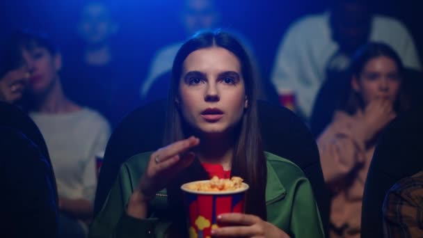Genç bir kadın sinemada ilginç bir film izliyor. Patlamış mısır yiyen çekici kız. — Stok video