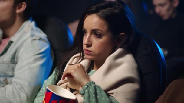 Chica impactada cerrando la cara en el interior. Mujer asustada viendo películas en el cine. — Vídeos de Stock