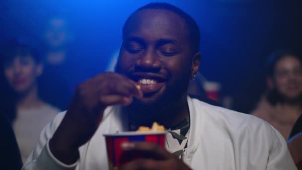 Neşeli Afro-Amerikan adam sinemada film izliyor. Afro adam patlamış mısır yiyor. — Stok video