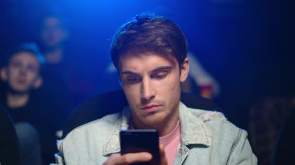영화에서 휴대 전화를 찾는 바쁜 사람. 어두운 홀에서 영화를 보고 있는 지루 한 남자. — 비디오