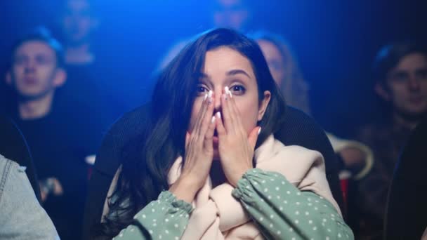 Una mujer conmocionada viendo películas de terror en el cine. Mujer asustada viendo película de terror — Vídeos de Stock