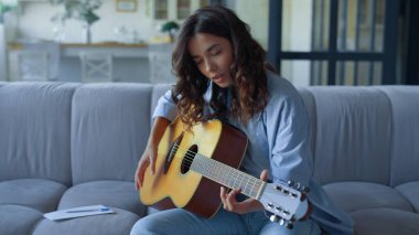 Gitarda şarkı yapan kız. Gitarist telli enstrümanla akorlar çalıyor