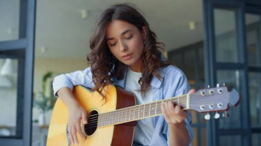 Gitarla müzik yapan bir kız. Gitarda akor çalan kadın gitarist.