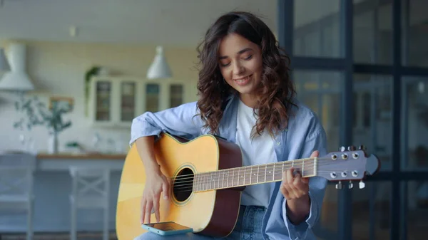 En tjej som spelar gitarr. Kvinnlig gitarrist spelar in gitarrljud på mobiltelefon — Stockfoto